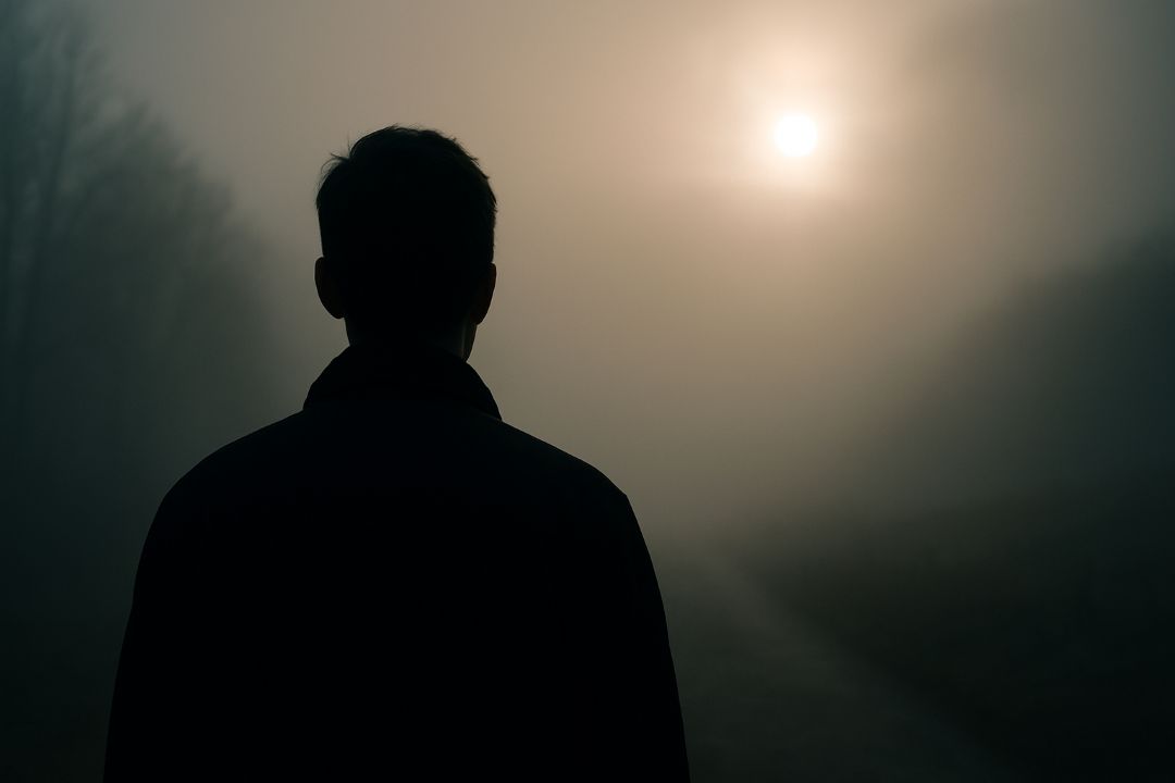 Sisli bir yolda ufka bakan kişinin silueti  ölüm kaygısı ve varoluşsal belirsizlik teması