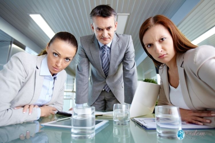 İki kadın ve bir erkek kameraya sert bir bakış yapmakta