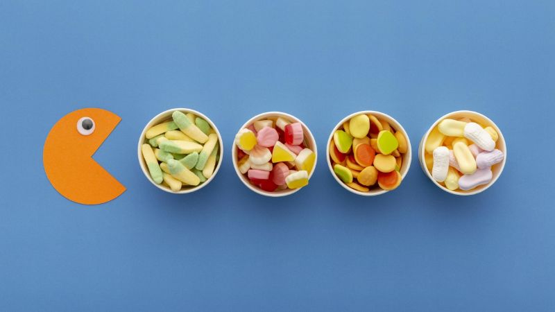 Pac-Man figürü ve renkli haplar – dopamin bağımlılığı ve ödül sistemi sembolü