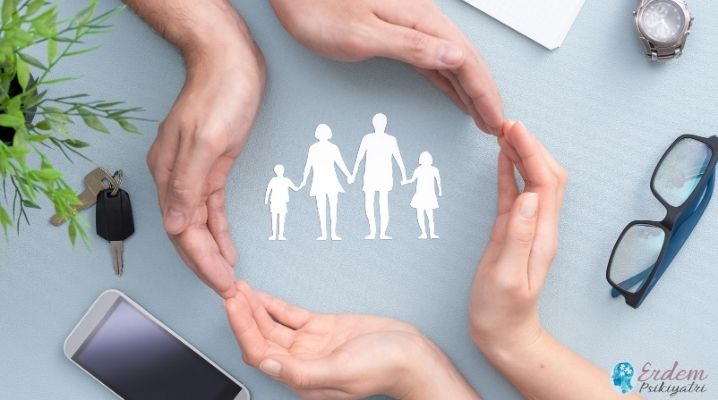 Koruyucu aile temsili olarak eller ile korunmuş ortada anne baba ve çocuk maketler