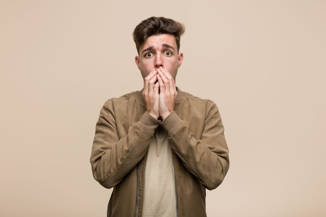 Kaygı yaşayan genç bir erkeğin endişeli yüz ifadesi; ani korku tepkisini ve modern hayattaki belirsizlik kaynaklı kaygıyı yansıtan görsel.