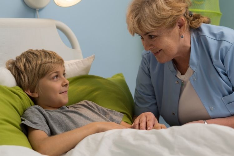 Öz şefkat gösteren bir yaşlı ve yatakta yatan bir çocuk