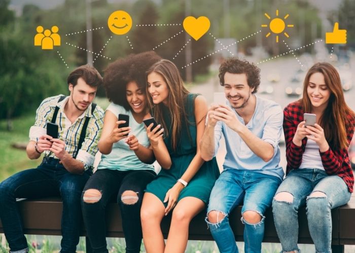 Ellerinde telefon ve sosyal medya takip eden gençler