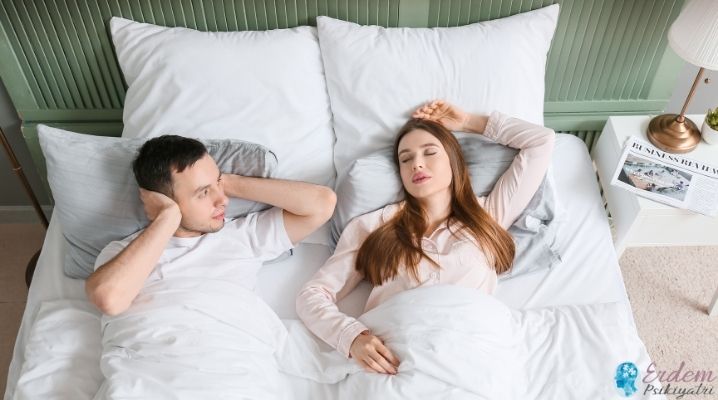 Uyku apnesi olan bir kadın ve eşi yatakta sıkıntı çekmektedir.