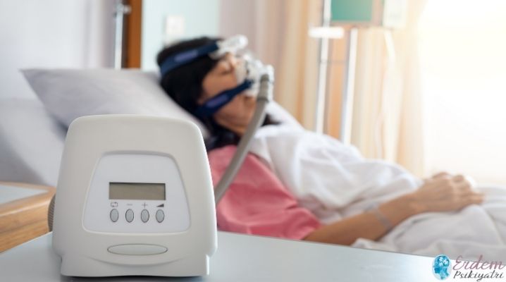 Uyku apnesi tedavisi olan kadın bir hasta yatakta yatıyor